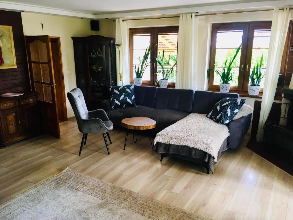 ein Wohnzimmer mit einem blauen Sofa und einem Tisch in der Unterkunft Dom Wakacyjny na Mazurach in Ogonki