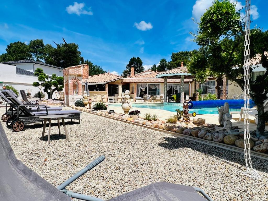 a backyard with a swimming pool and a house at Le Mas des Mathes, Chambres d&#39;hôtes, Studios in Les Mathes