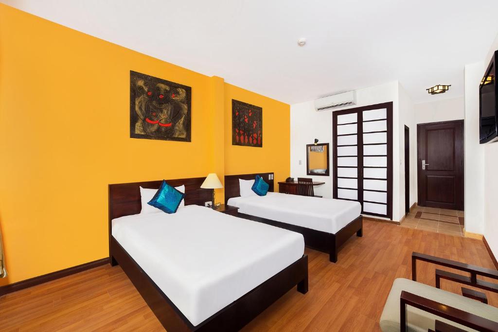Postel nebo postele na pokoji v ubytování Gold Coast Da Nang Hotel