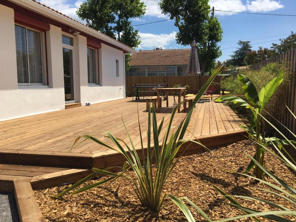 a wooden deck in a backyard with a table at La Casita in Arès