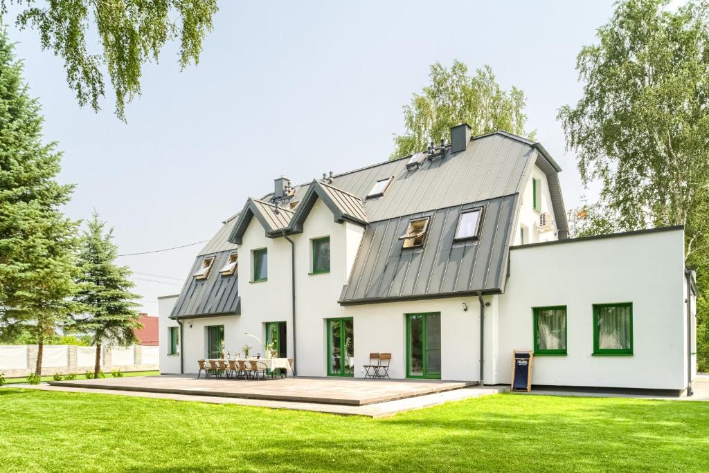 uma casa branca com um telhado de gambrel em Tucholska 3 em Tleń