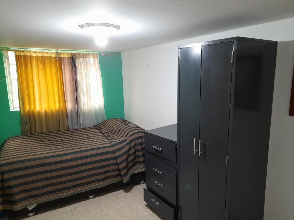 1 dormitorio con 1 cama y vestidor negro en Mi hospedaje, en Bogotá