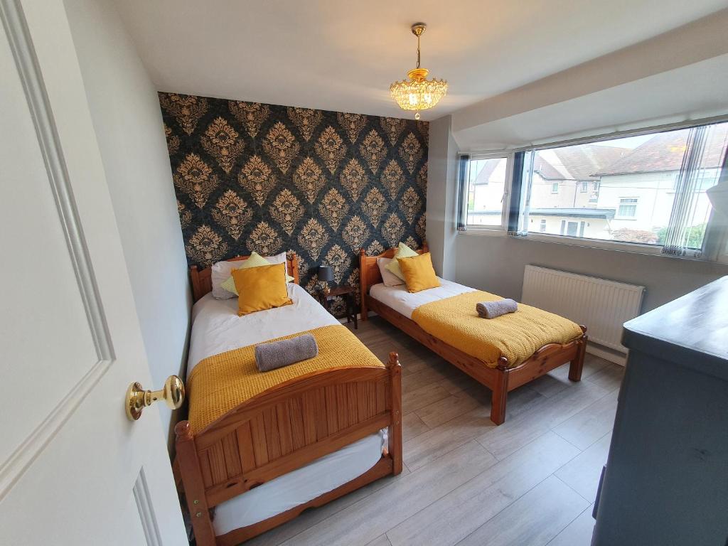 una piccola camera con due letti e una finestra di Luxury Victorian Home Slough, Legoland, Windsor a Slough