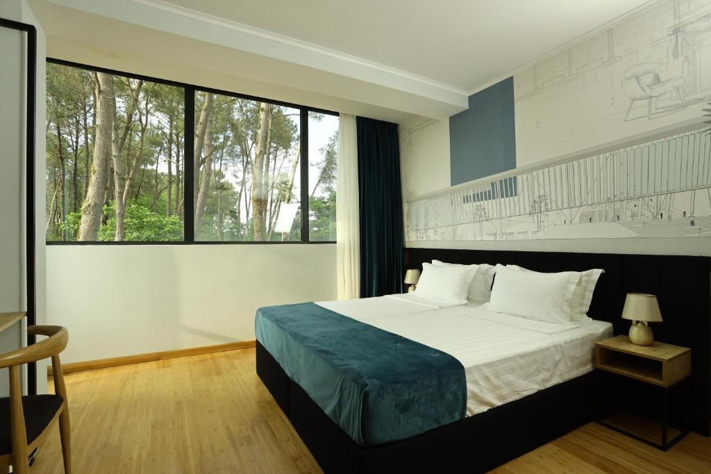 a bedroom with a bed and a large window at Graphica Black Sea in Shekhvetili