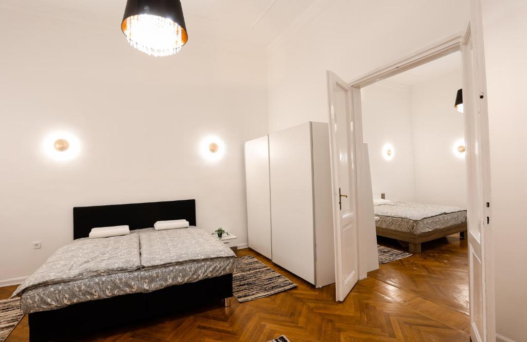 a white bedroom with a bed and a mirror at Chain Bridge City Center Dorothea in Budapest