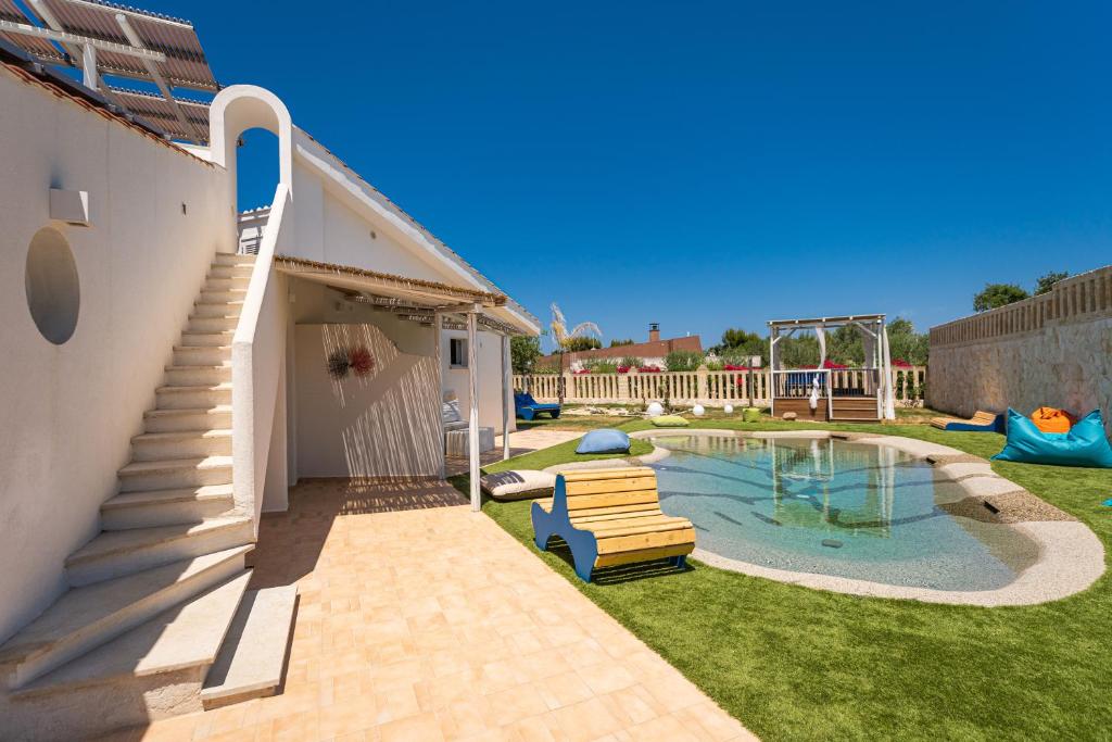 a backyard with a pool with two chairs and a playground at Don Leonardo - pool and wellness in Polignano a Mare