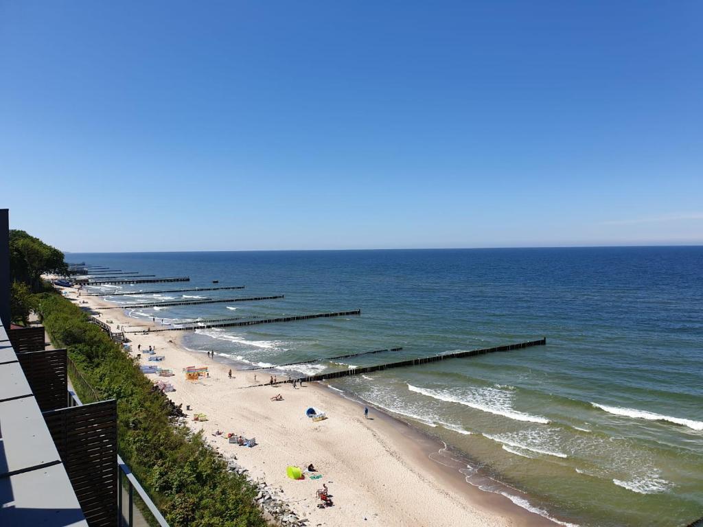 a beach with a long line of pier at SAILOR Ustronie Morskie in Ustronie Morskie