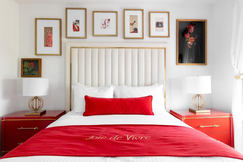 a bedroom with a red and white bed with pictures on the wall at The Vendue, Downtown Art Hotel in Charleston