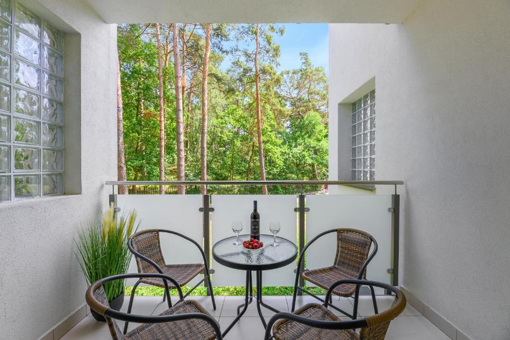 a balcony with a table and chairs and a window at Apartamenty PIAMOLA Bursztynowe Osiedle Jantar in Jantar