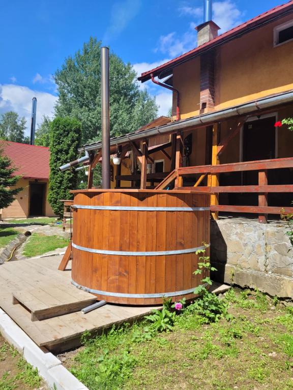 une baignoire en bois installée à l'extérieur d'une maison dans l'établissement Cabana Sebes Bera, à Făgăraş