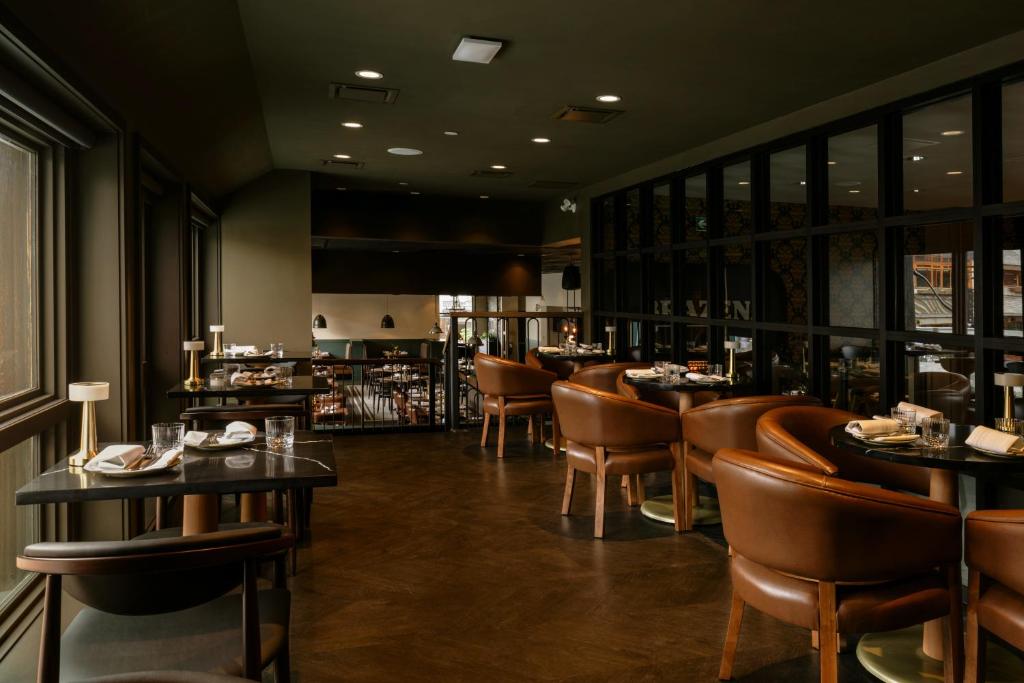 a restaurant with tables and chairs and a bar at Mount Royal Hotel in Banff