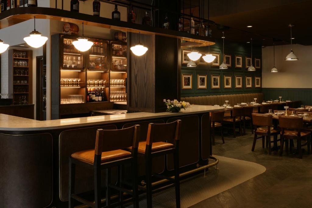 a bar in a restaurant with tables and chairs at Mount Royal Hotel in Banff