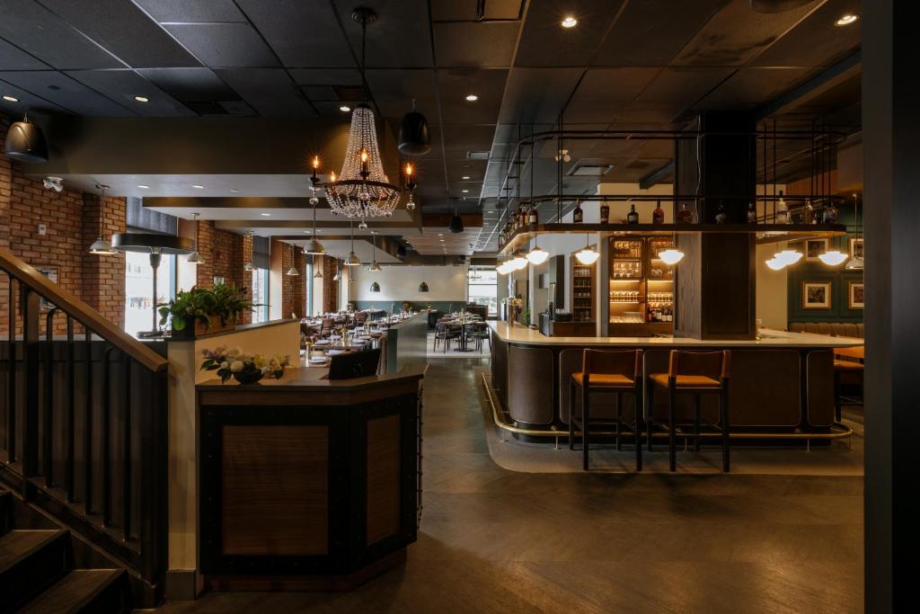 a bar in a restaurant with a bar stools at Mount Royal Hotel in Banff