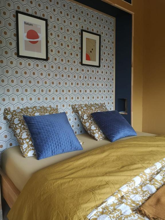 - une chambre avec 2 oreillers bleus sur un lit dans l'établissement Le Petit Astro parking privé, à Turckheim