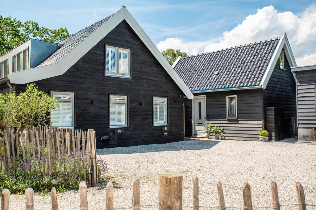 a black house with a fence in front of it at Gîte81 in Reeuwijk