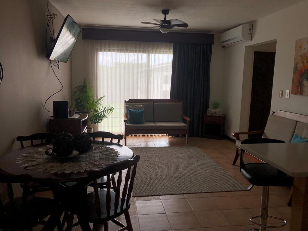 ein Wohnzimmer mit einem Tisch und einem Sofa in der Unterkunft Apartamento Chorotega in Liberia