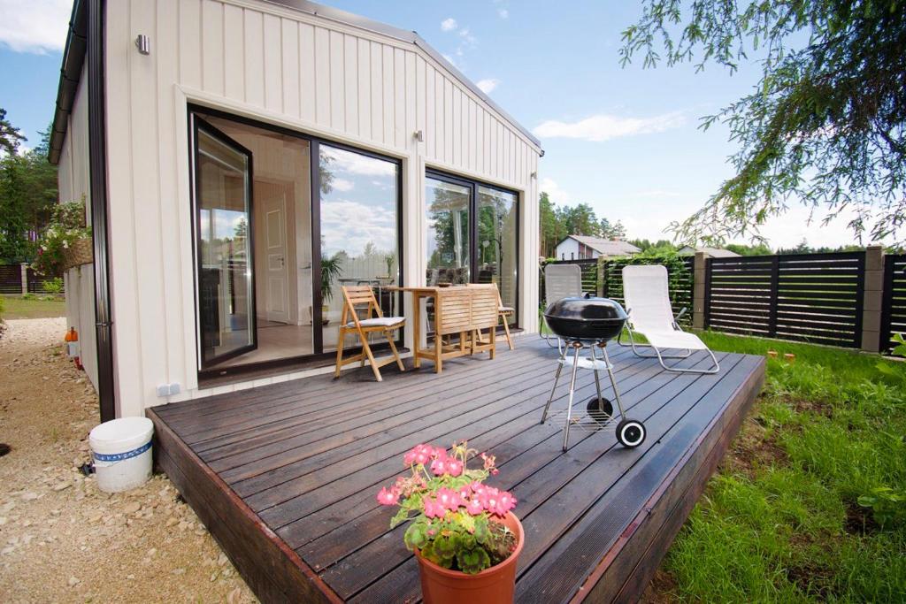 a wooden deck with a grill and a table at Villa Vlada in Saulkrasti