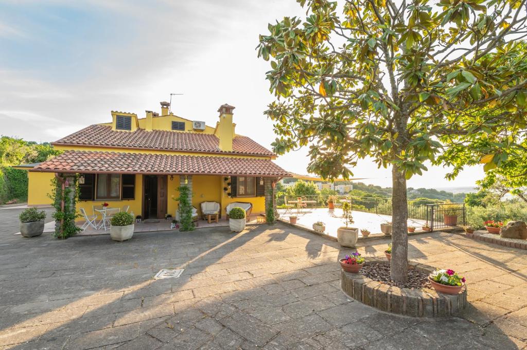 a yellow house with a tree in front of it at Casa Vacanze La Magnolia in Viterbo