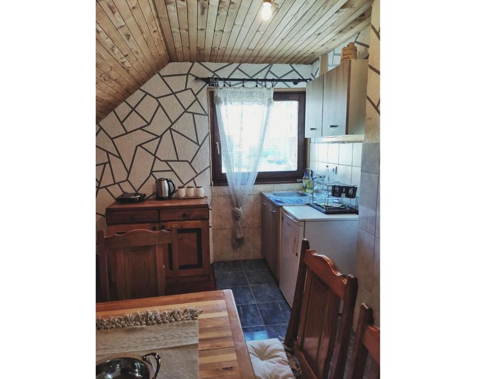 eine kleine Küche mit einem Waschbecken und einem Tisch in der Unterkunft Woden apartment in Žabljak