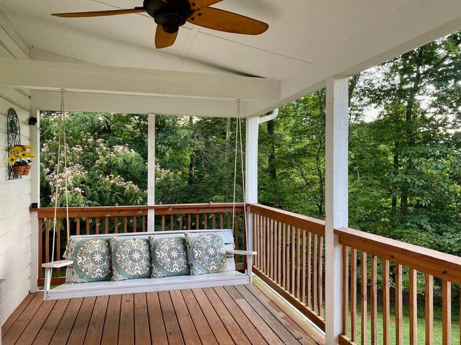 a porch with a ceiling fan and pillows on it at Beautiful 2 BR 1 BA Cabin in Blue Ridge Mountains: The Little White House in Martinsville