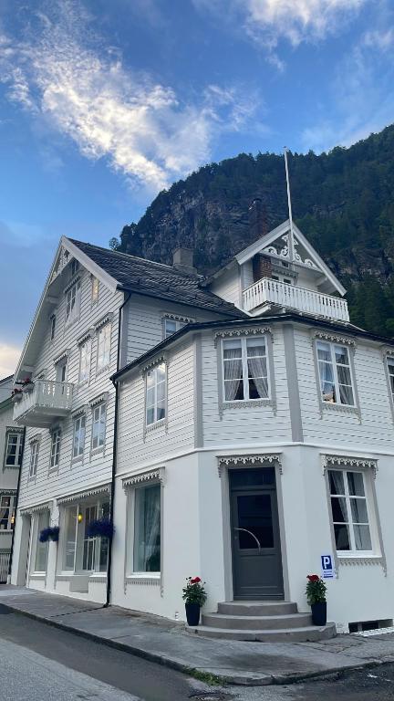 a large white building on the side of a street at Sylte Hotell, Valldal in Valldal