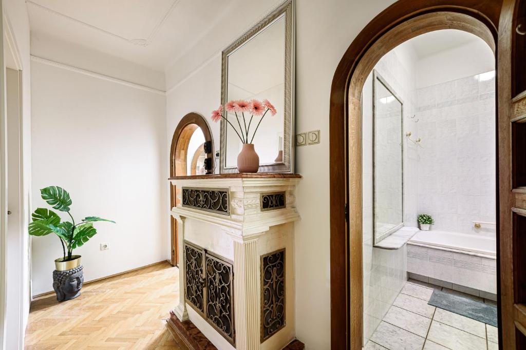 a bathroom with a fireplace and a mirror at Stylish Homes Downtown Buda in Budapest