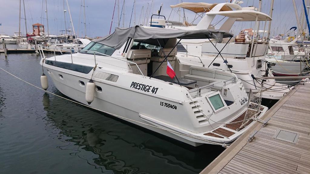 a white boat docked at a dock in the water at Le For Sea in Le Barcarès