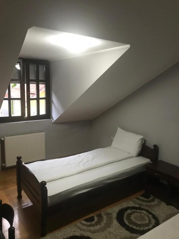 a bed in a room with a ceiling at Kaplarević Smeštaj Ivanjica in Ivanjica