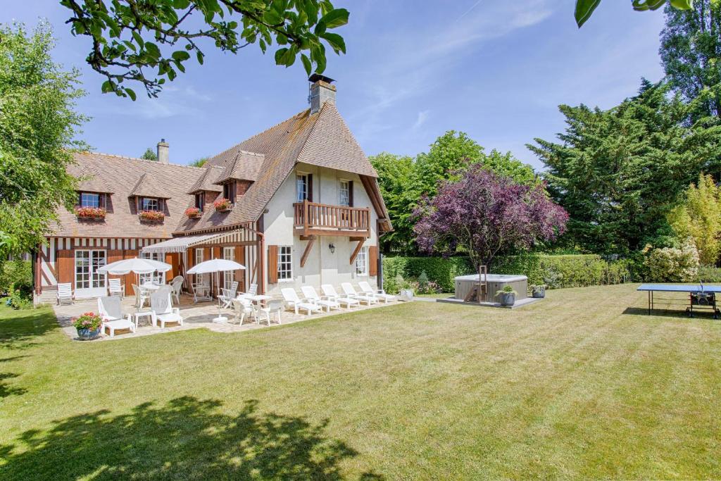 une maison avec une cour dotée de chaises et d'une table dans l'établissement Maison Normande avec Jardin et Jacuzzi, à Deauville