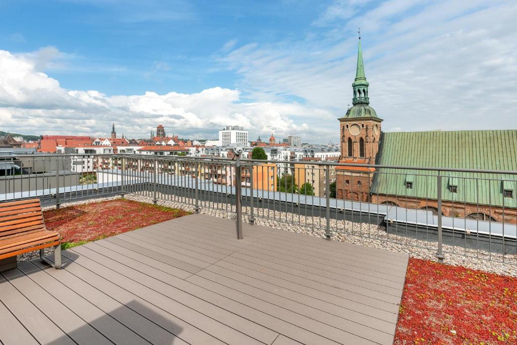balkon z ławką i wieżą zegarową w obiekcie City Center Garden Gates Boutique by Downtown Apartments w Gdańsku