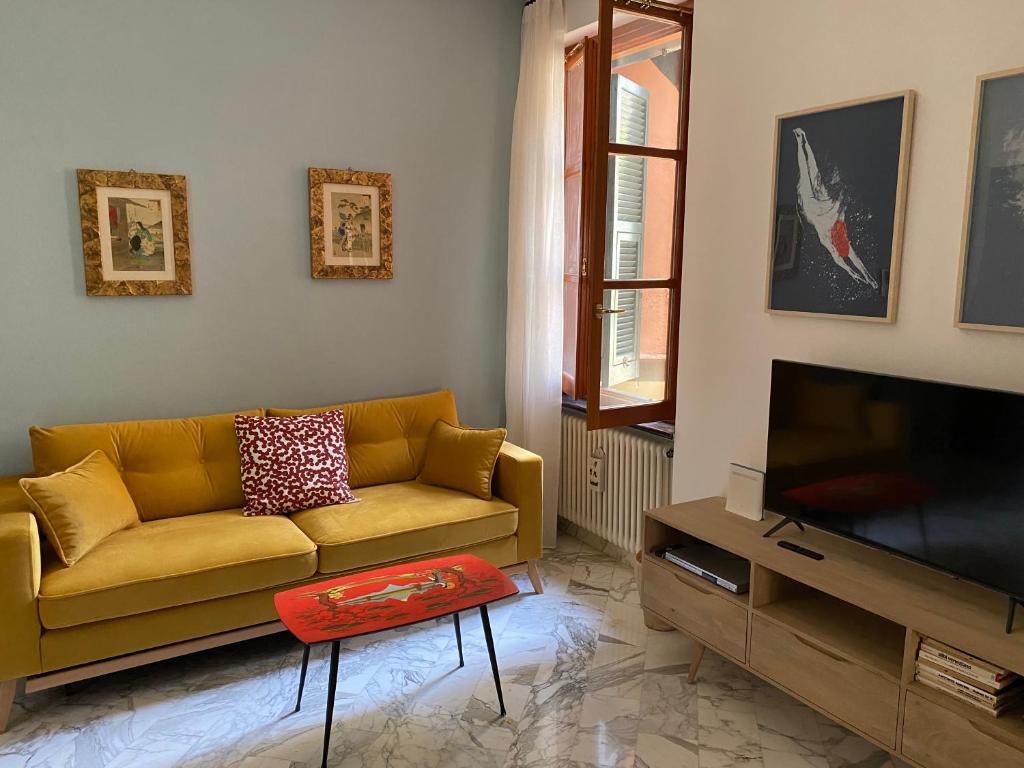 sala de estar con sofá amarillo y TV en Casa del Monastero, en Chiavari