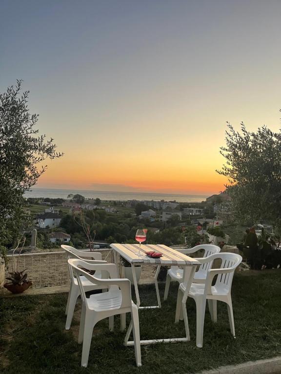 a table and chairs with a sunset in the background at MEGA Apartments in Fushë-Draç