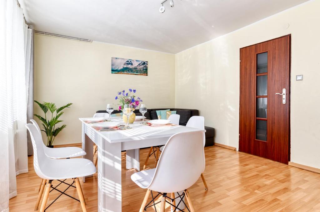 uma sala de jantar com uma mesa branca e cadeiras brancas em Apartament Arturro z ogródkiem em Szklarska Poręba