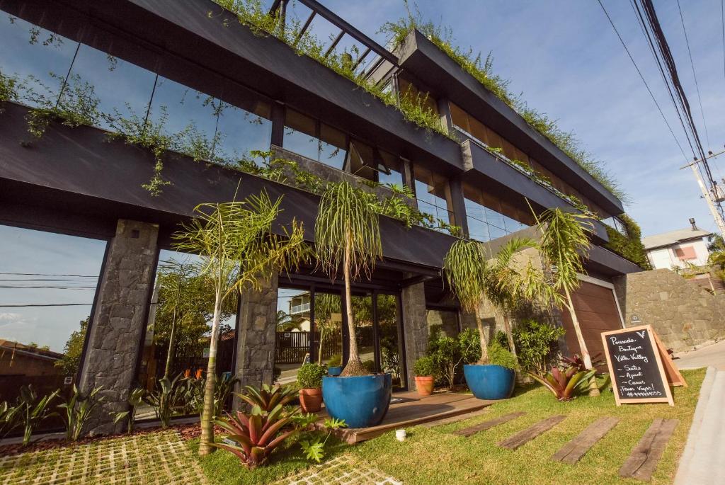 a building with plants on the side of it at Pousada Boutique Villa Valley in Praia do Rosa
