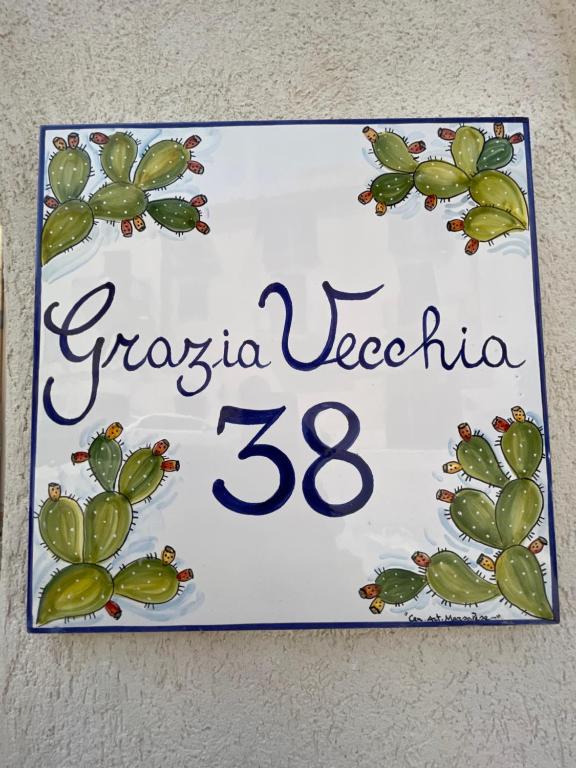 a sign on a wall with a cactus at Grazia Vecchia 38 in Marsala