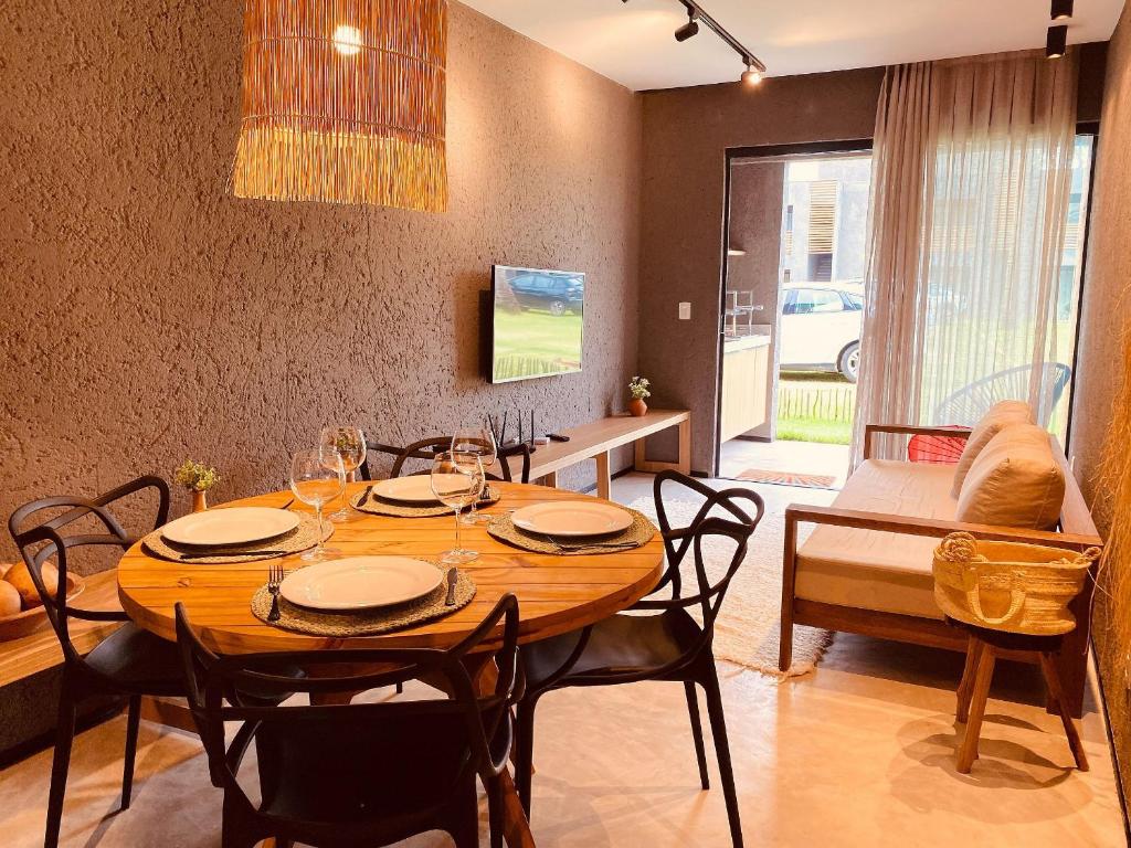 - une salle à manger avec une table et des chaises en bois dans l'établissement Villas Patacho - Milagres Apto 002 Bloco A ( ER Hospedagens ), à Porto de Pedras