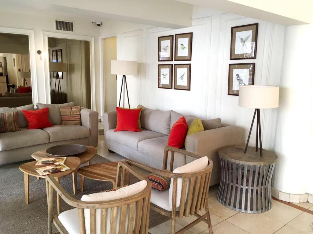 uma sala de estar com um sofá, uma mesa e cadeiras em MR Express (ex Hotel Neruda Express) em Santiago