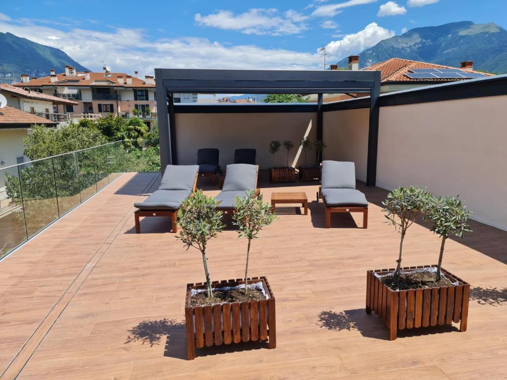 un patio all'ultimo piano con sedie e alberi di Garda Family & Solarium a Riva del Garda