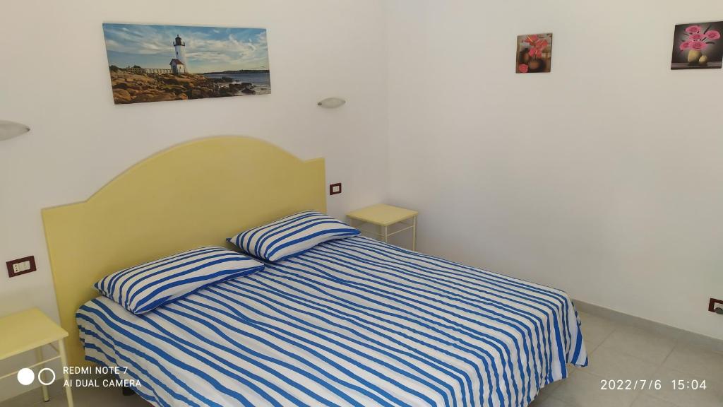 una camera con un letto con una coperta a righe blu e bianche di Camera felice a Campomarino