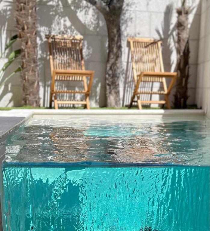 a swimming pool with two chairs and some water at Villa Charles in Trogir