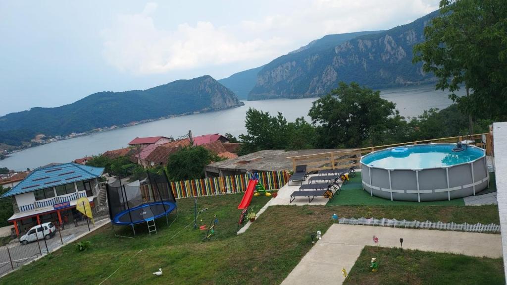 a view of a large swimming pool and a lake at Casa De Vacanță Maga Dubova in Dubova