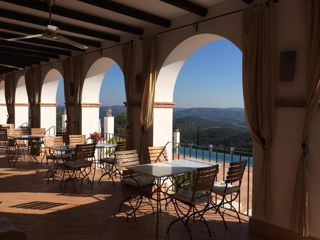 a patio with tables and chairs on a balcony at Casa Vesta in Zufre