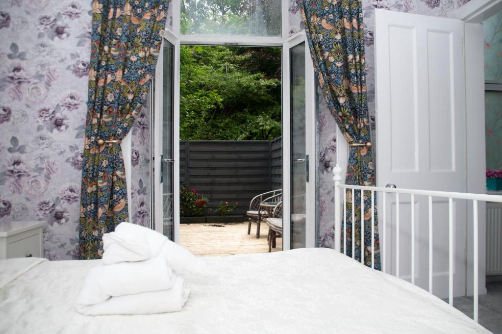 1 dormitorio con 1 cama y puerta corredera de cristal en Family Apartment - Skye - Private Members Club, en Edimburgo