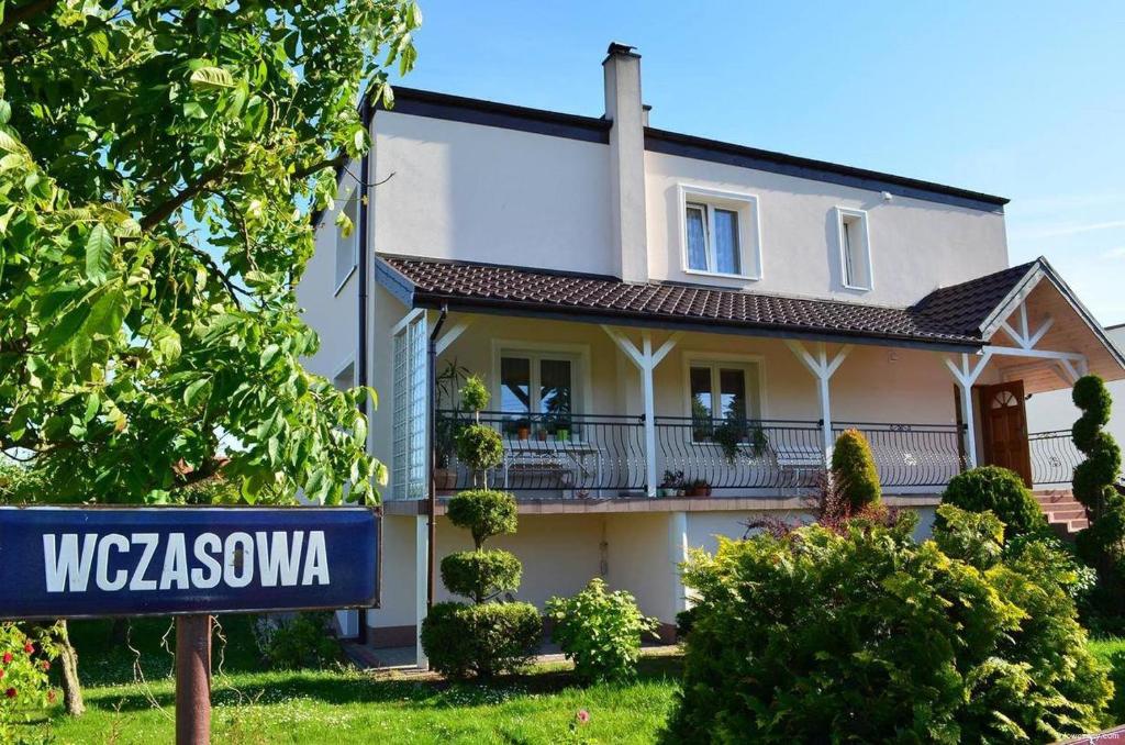 ein Haus mit einem Straßenschild davor in der Unterkunft Pokoje gościnne u Małgosi in Jarosławiec