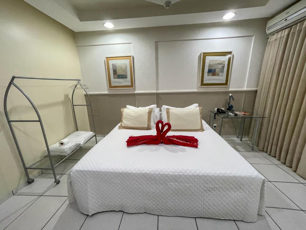 a bedroom with a bed with a red bow on it at Canadá Hotel in Rio Verde