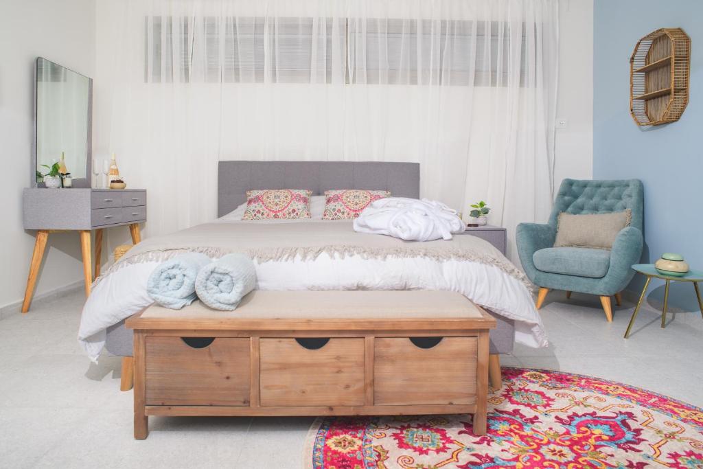 sypialnia z dużym łóżkiem i drewnianym stołem w obiekcie PRINCESS of the Dead Sea by CROWN w mieście Newe Zohar