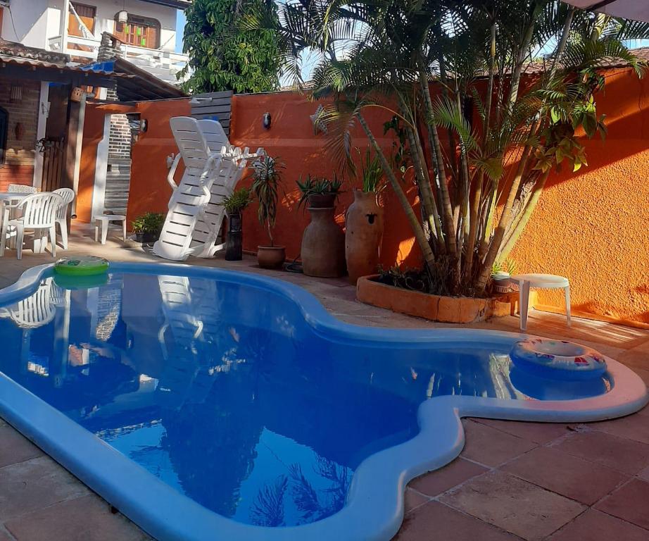 una gran piscina azul en un patio en Pousada do Carlos, en Arraial d'Ajuda
