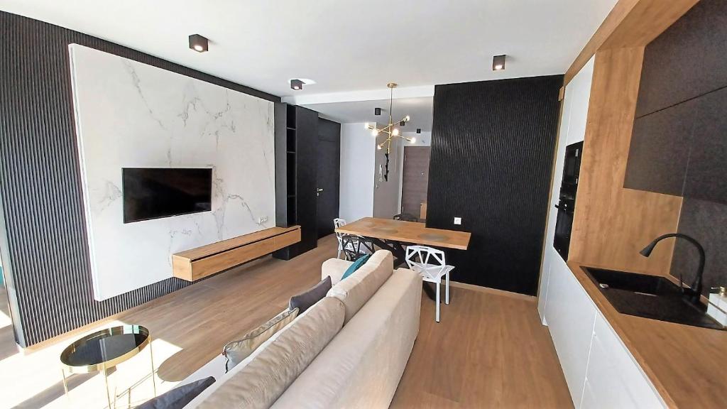 Televízia a/alebo spoločenská miestnosť v ubytovaní Kima Apartament Bażantów 44