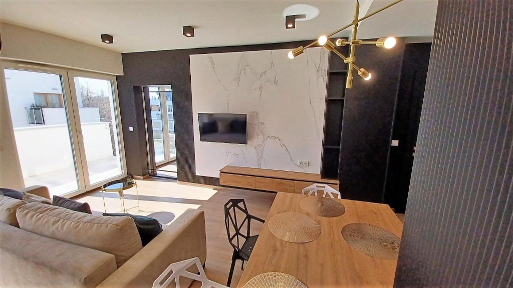 Televízia a/alebo spoločenská miestnosť v ubytovaní Kima Apartament Bażantów 44