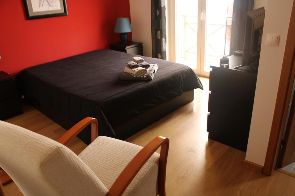 ロウリニャンにあるGrillohouseの赤い部屋のベッド1台が備わるベッドルーム1室